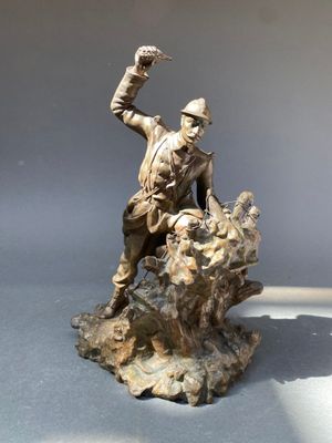 statue d'un homme assis sur un rocher, tenant un oiseau dans la main