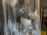a picture of a refrigerator wrapped in plastic and sitting in a garage