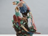 une figurine représentant deux perroquets perchés sur une branche d'arbre