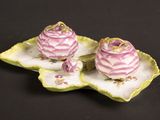 deux petites fleurs roses sur une assiette en forme de feuille verte