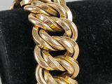 a close up of a gold bracelet on a black ring