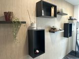 two shelves on the wall with vases on them