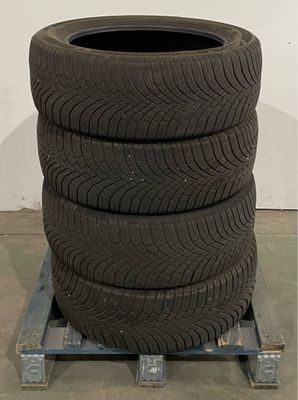 three tires are stacked on a pallet in a warehouse