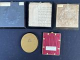 three books and a plaque on a table with a blue background