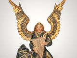 a statue of an angel with a harp sits on the ground