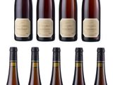 a group of six bottles of wine sitting next to each other