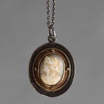 a close up of a necklace with a picture of a woman on it