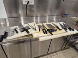 de nombreux couteaux posés sur une planche à découper, sur le plan de travail de la cuisine