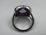 a close up of a ring with a purple stone in it