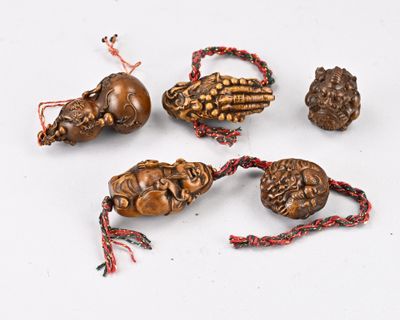 six objets en bois sculpté posés sur une surface blanche, entourés d'une ficelle rouge