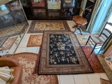 un salon avec une cheminée et un grand tapis au sol