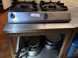 un plan de travail en acier inoxydable sur lequel sont posés des casseroles et des poêles