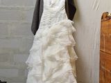 a wedding dress hanging on a hanger in a room