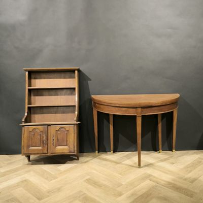 two wooden tables and a cabinet in a room with a gray wall