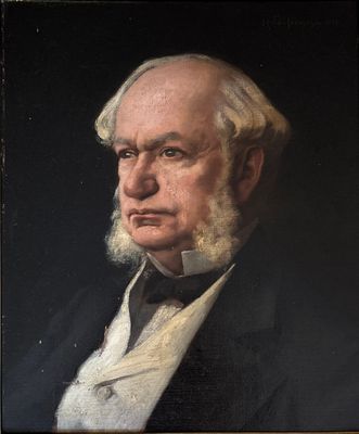 portrait of an old man with a white beard in a black suit