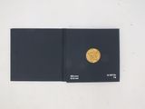 a black book with a gold coin on top of it