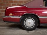 a red car that is parked in front of a brick wall