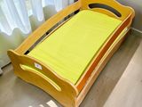 un lit en bois recouvert d'un drap jaune