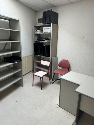 une pièce contenant un bureau, des étagères et une chaise