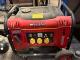 a red and black generator on the floor in a garage