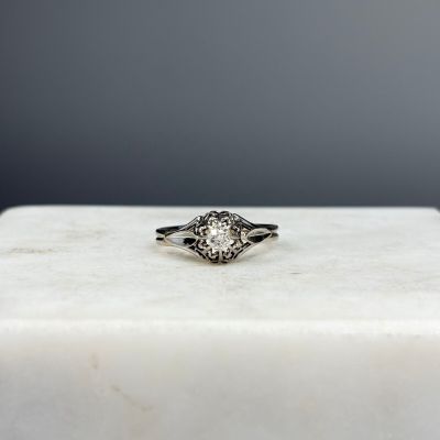 un gros plan d'une bague en diamant posée sur un bloc de marbre