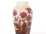 un vase avec un motif floral sur une surface blanche