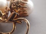 a close up of a pair of earrings with pearls on them