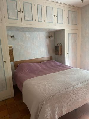 un lit avec une tête de lit intégrée, placé au milieu d'une pièce