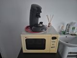 a small microwave with a coffee maker on top of it