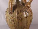 un vase marron orné d'un oiseau sur fond blanc