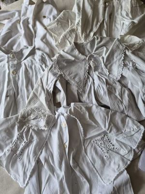 un tas de vêtements blancs posé sur un lit