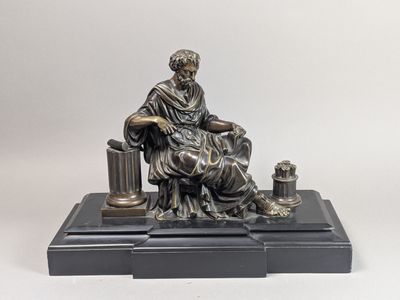 une image représentant la statue d'un homme assis sur une table