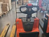 an image of a forklift in a warehouse with pallets in the background
