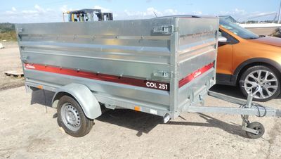 a trailer with a trailer attached to it and a car in the background