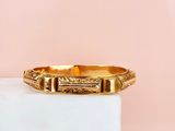 a close up of a gold ring sitting on top of a white block