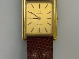 une photo d'une montre en cuir marron avec un cadran plaqué or