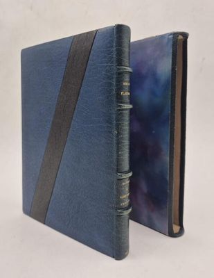 un livre bleu orné d'une bande noire est ouvert sur une surface blanche