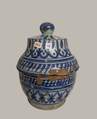 a blue and white vase with a lid on a table