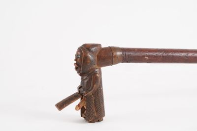 an old wooden stick with a man holding a stick