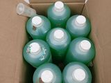 une boîte en carton remplie de bouteilles d'eau posée sur une surface blanche