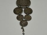 a close up of a necklace with coins hanging from it