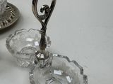 a silver plate with a glass candle holder and a silver plate with a silver candle holder on it