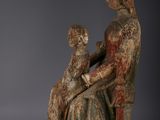 an old statue of a woman holding a child in her lap