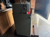 a small refrigerator sitting on a pallet in a garage