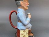 a figurine of a man with a hat and a pipe
