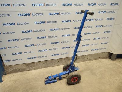 an image of a blue hand truck parked in front of a wall