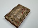 a close up of a small book on a white surface