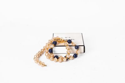 un bracelet en or orné d'une perle bleue et d'une chaîne en or