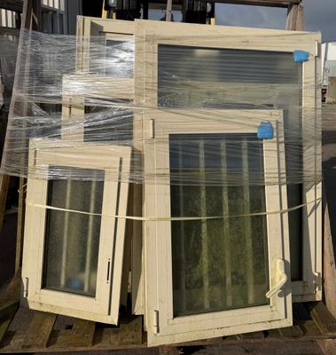 many windows sitting on a pallet in a warehouse
