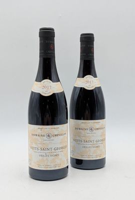 deux bouteilles de vin posées l'une à côté de l'autre sur une surface blanche